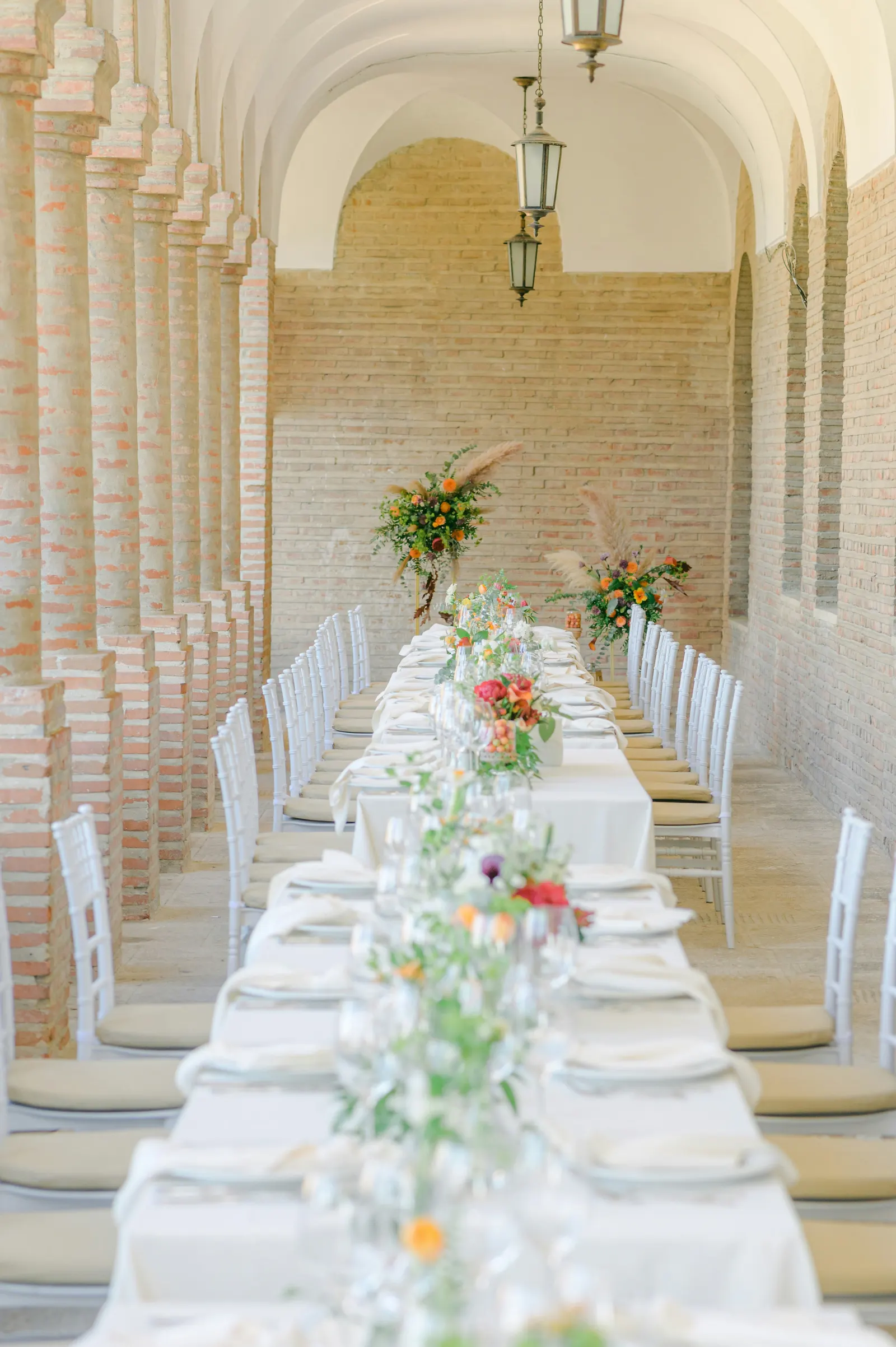 A white table laid for a feast in the bright arcade
