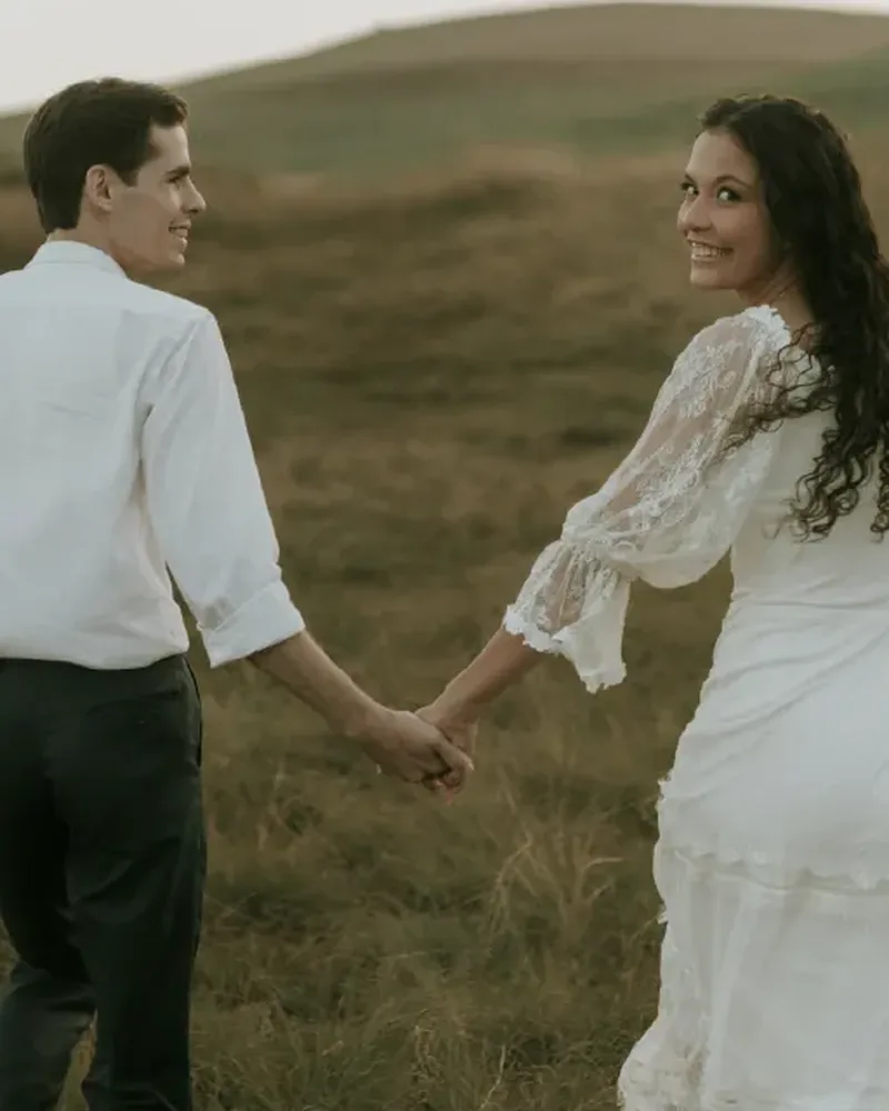 Oliver and Marie walking hand in hand through the dunes
